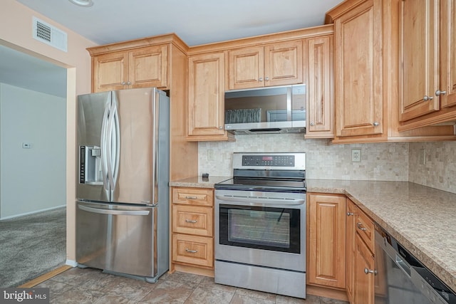 kitchen with stainless steel appliances, light carpet, and backsplash