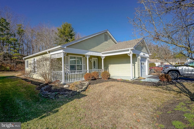 view of side of home featuring a garage, a yard, and covered porch