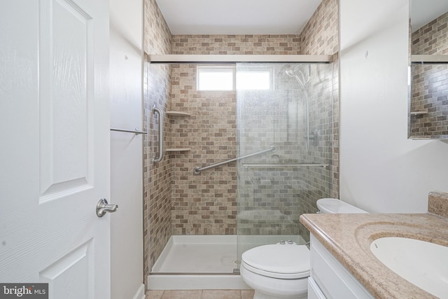 bathroom featuring vanity, toilet, an enclosed shower, and tile patterned flooring