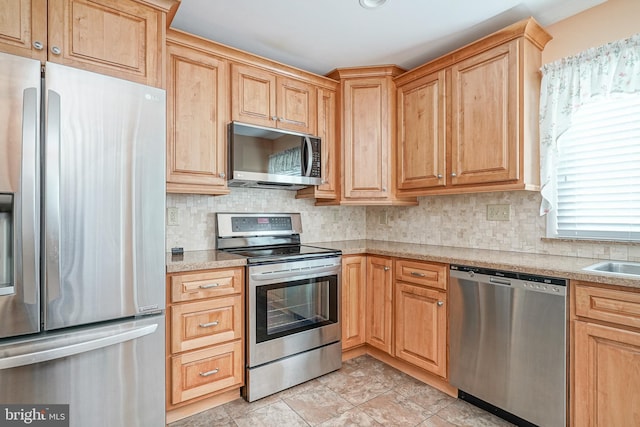 kitchen featuring stainless steel appliances, sink, and decorative backsplash