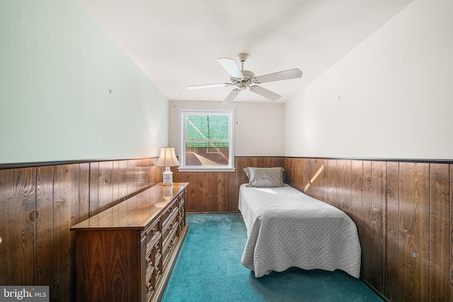 bedroom with wooden walls and dark carpet