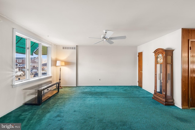 carpeted spare room featuring ceiling fan