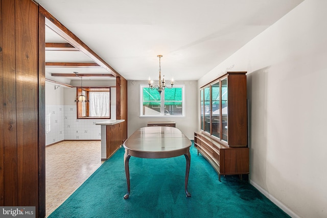 unfurnished dining area featuring plenty of natural light, a chandelier, and carpet floors