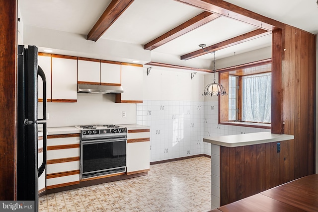 kitchen featuring hanging light fixtures, beam ceiling, gas stove, white cabinets, and black fridge