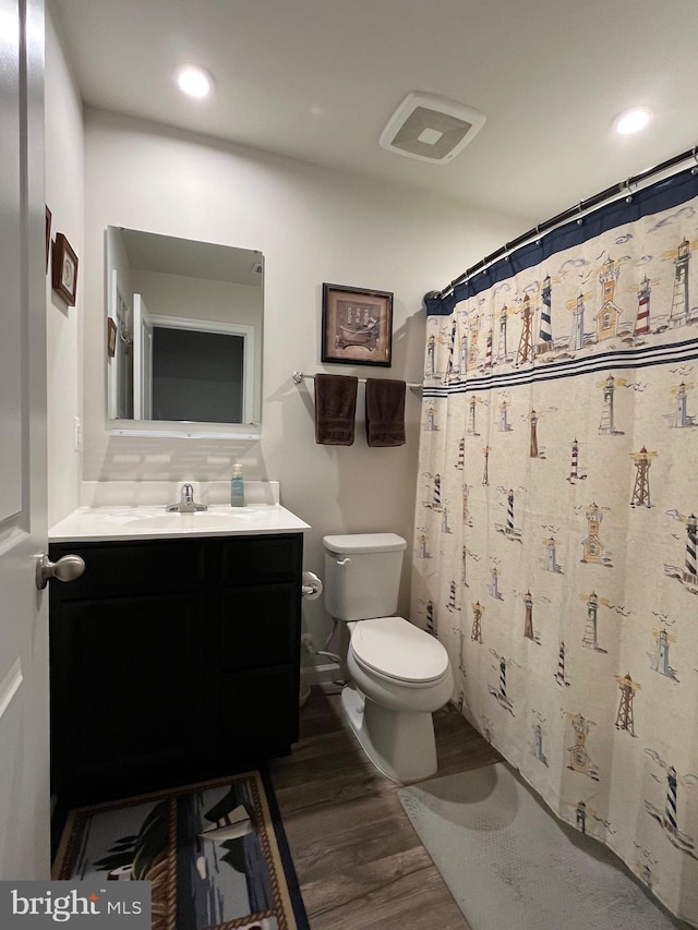 bathroom featuring tasteful backsplash, vanity, toilet, and hardwood / wood-style floors