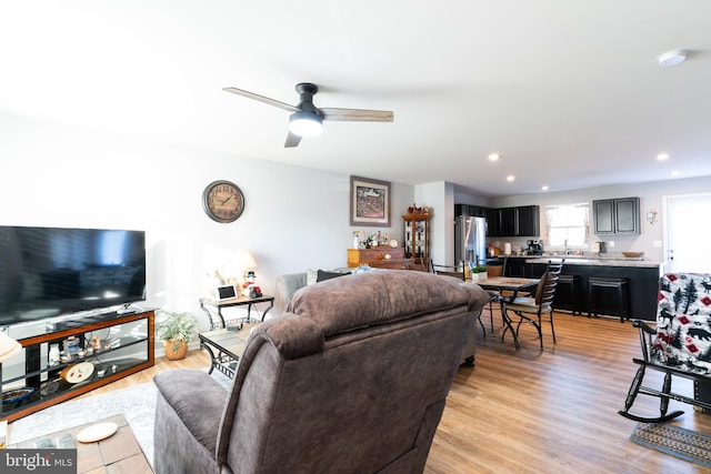 living room featuring ceiling fan and light hardwood / wood-style flooring