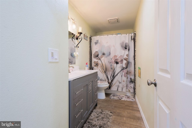 bathroom featuring vanity, hardwood / wood-style flooring, toilet, and a shower with shower curtain