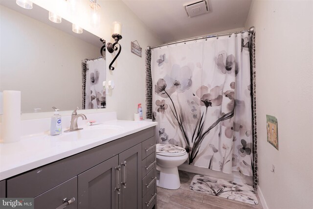 bathroom with hardwood / wood-style flooring, vanity, and toilet