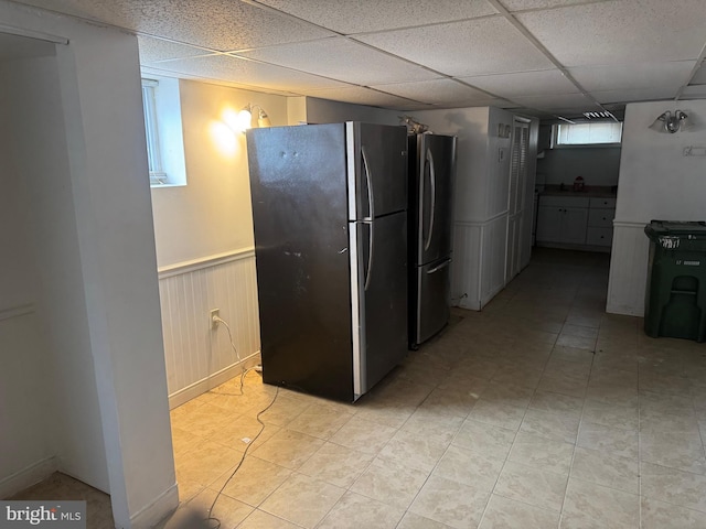 kitchen with stainless steel fridge and a paneled ceiling