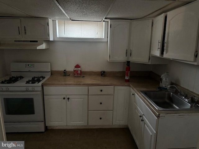 kitchen with white range with gas cooktop, sink, and white cabinets