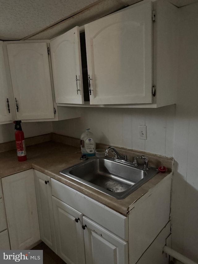 kitchen featuring white cabinetry and sink