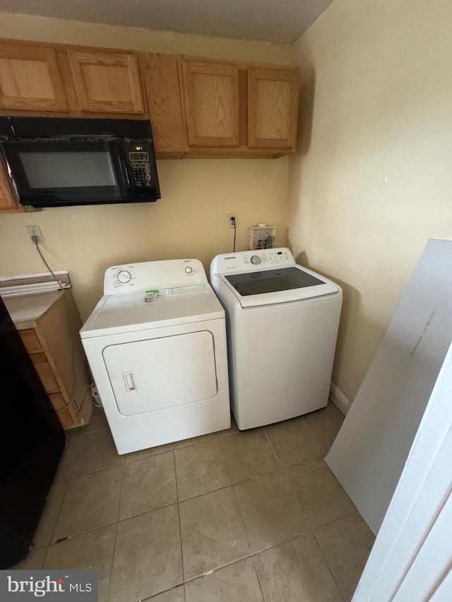 clothes washing area with washing machine and dryer and light tile patterned floors