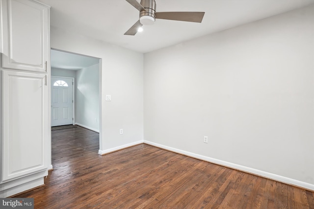 empty room with ceiling fan, baseboards, and dark wood-style flooring