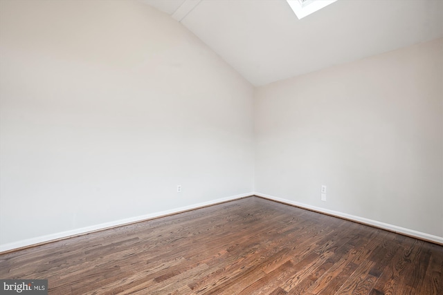 unfurnished room with vaulted ceiling with skylight, baseboards, and dark wood finished floors