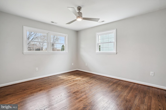 empty room with visible vents, baseboards, and wood finished floors