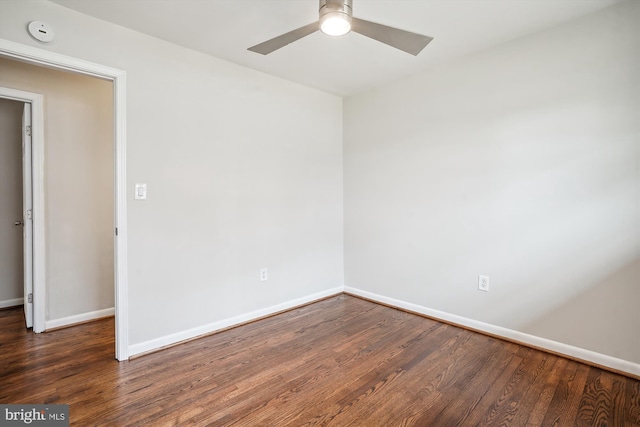 empty room featuring wood finished floors, a ceiling fan, and baseboards