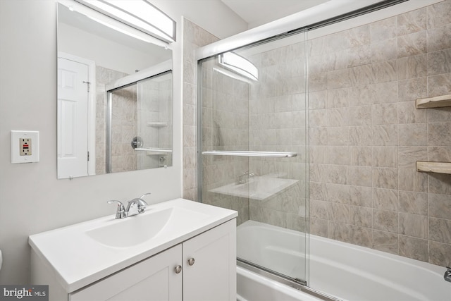 bathroom with shower / bath combination with glass door and vanity