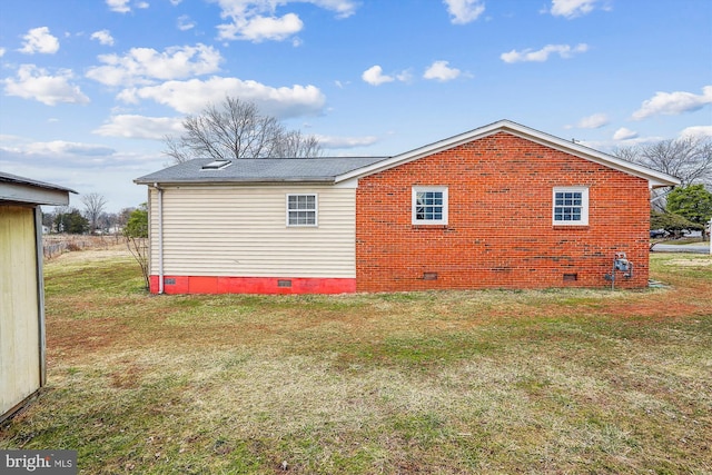 view of side of property featuring crawl space, roof with shingles, a lawn, and brick siding