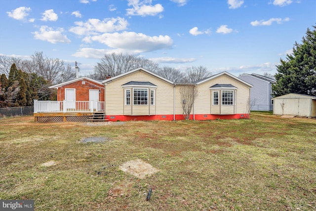 back of house with an outbuilding, a lawn, a storage shed, crawl space, and a wooden deck