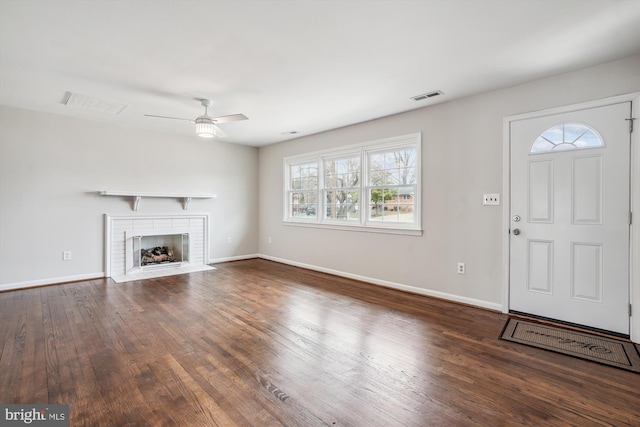 unfurnished living room with a fireplace with flush hearth, wood finished floors, visible vents, and baseboards