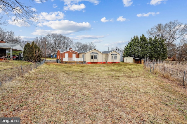 view of front of home with a storage shed, a front yard, a fenced backyard, and an outdoor structure