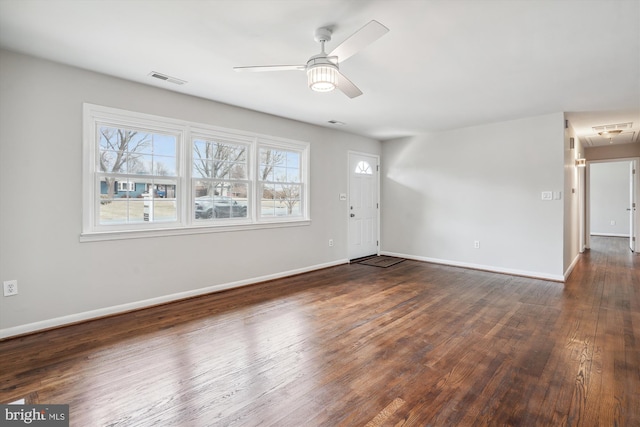 interior space with visible vents, hardwood / wood-style floors, attic access, ceiling fan, and baseboards