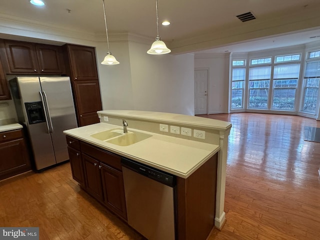 kitchen with dark brown cabinetry, sink, a kitchen island with sink, and appliances with stainless steel finishes