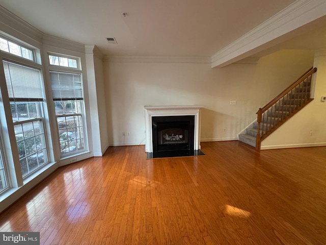 unfurnished living room with wood-type flooring and ornamental molding