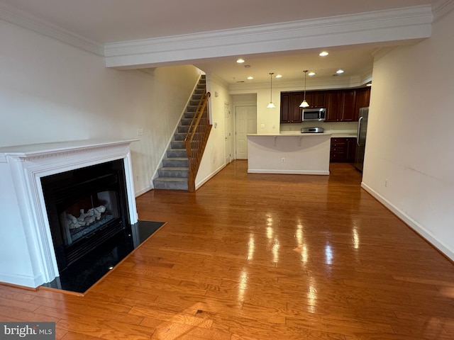 unfurnished living room featuring ornamental molding and hardwood / wood-style floors