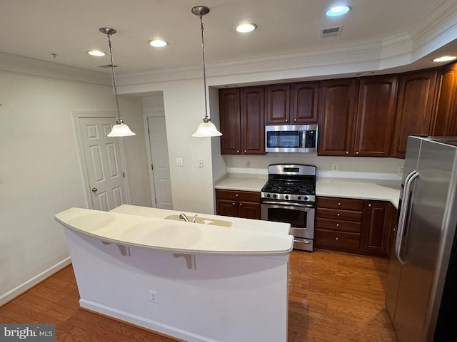 kitchen featuring stainless steel appliances, crown molding, dark hardwood / wood-style floors, and decorative light fixtures