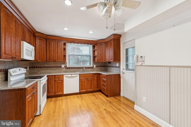 kitchen with sink, backsplash, ceiling fan, white appliances, and light hardwood / wood-style flooring