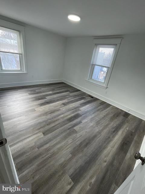 empty room with dark hardwood / wood-style flooring