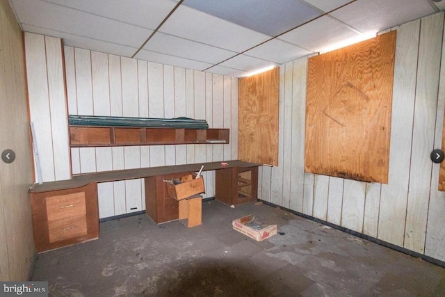 miscellaneous room featuring a paneled ceiling and wooden walls