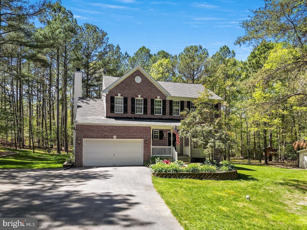 view of front of house featuring a porch, a garage, and a front yard