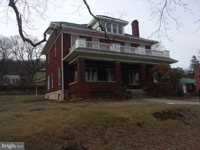 view of front of property with a balcony and a front lawn