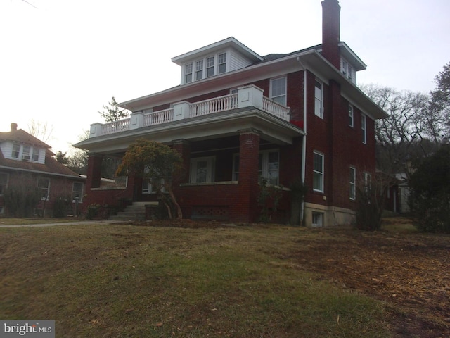 view of front of home with a balcony and a front lawn