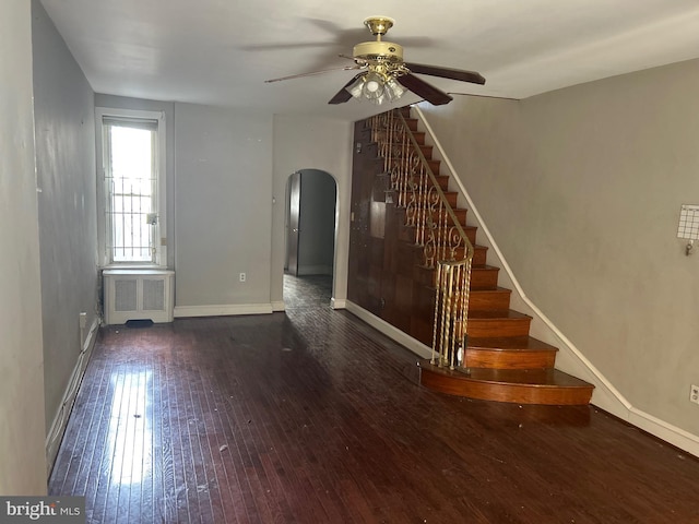 unfurnished living room with ceiling fan, radiator, and dark hardwood / wood-style flooring