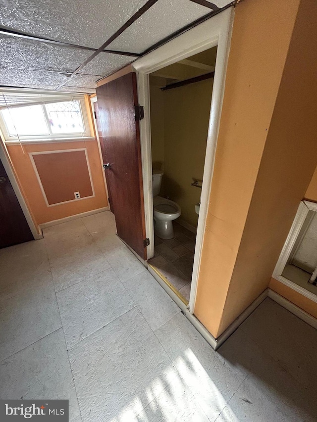 bathroom featuring a paneled ceiling and toilet