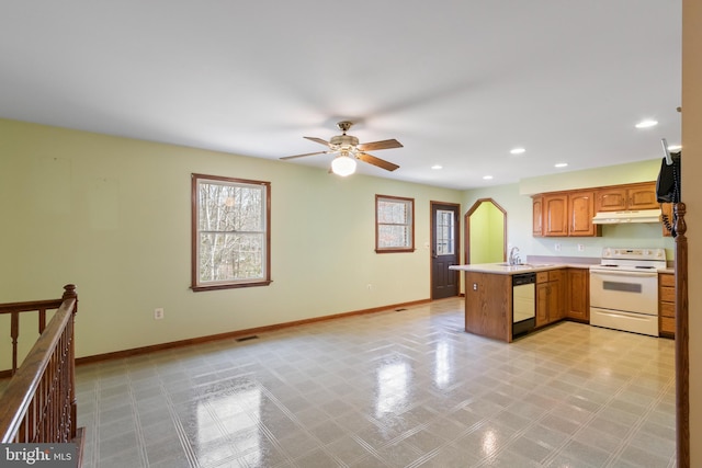 kitchen featuring a healthy amount of sunlight, white electric range, kitchen peninsula, and black dishwasher