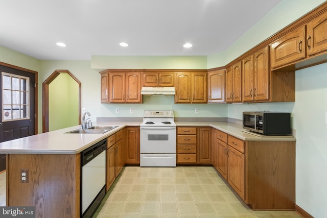 kitchen with sink, white appliances, and kitchen peninsula