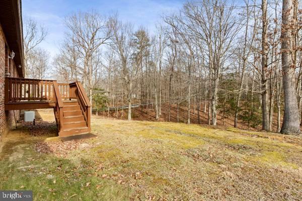 view of yard featuring a wooden deck and central AC