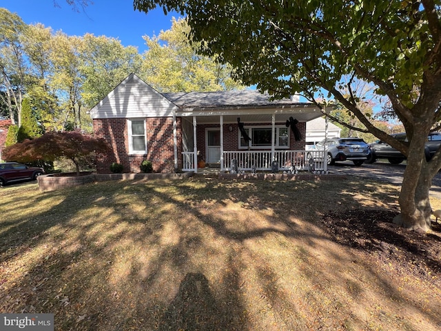 single story home with a front yard and a porch