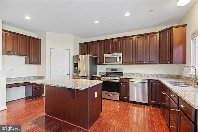 kitchen featuring sink, a kitchen breakfast bar, dark hardwood / wood-style flooring, a kitchen island, and stainless steel appliances