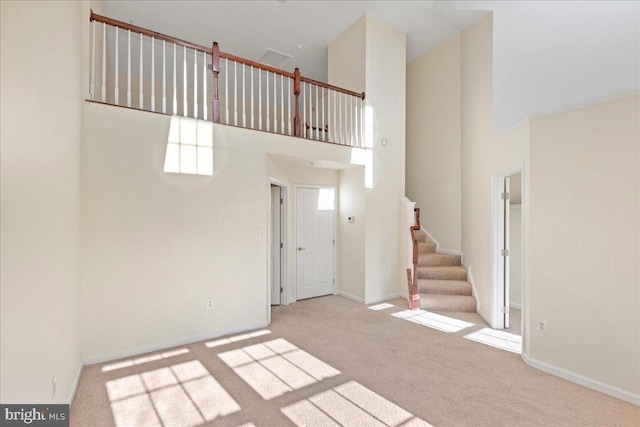 interior space with a high ceiling and light colored carpet