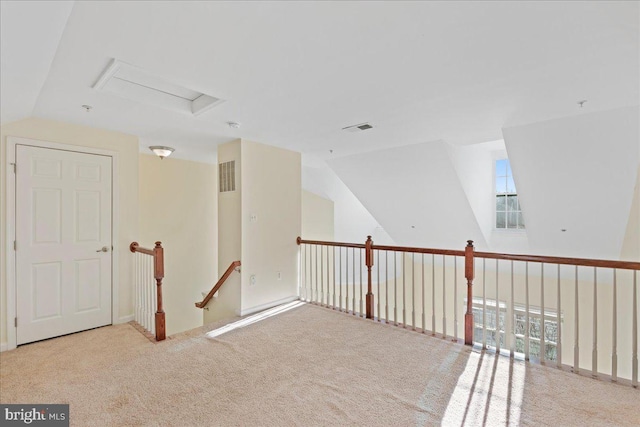 interior space with vaulted ceiling and light colored carpet