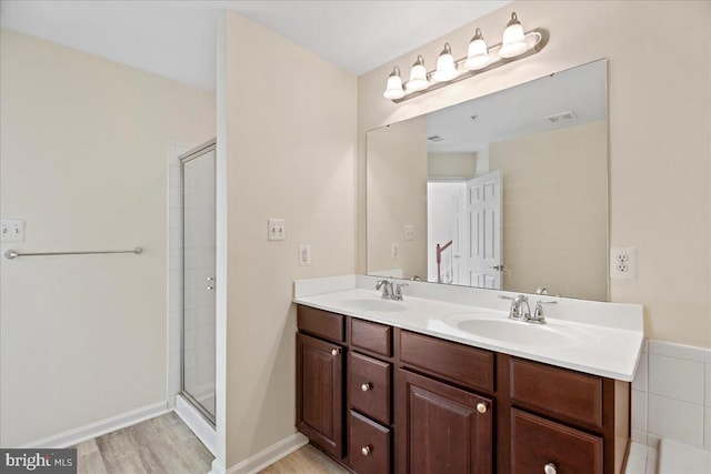 bathroom featuring vanity, wood-type flooring, and a shower with door