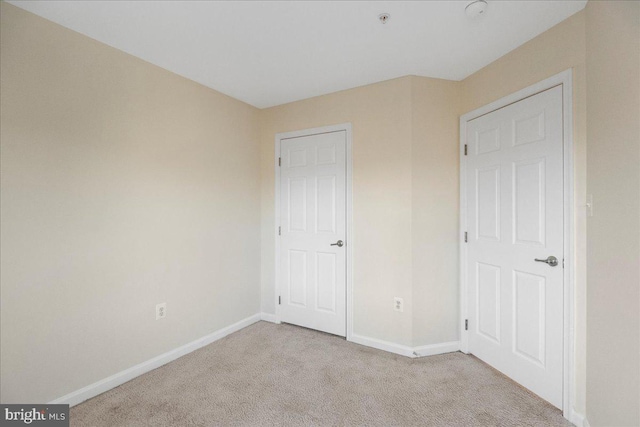 unfurnished bedroom featuring light carpet