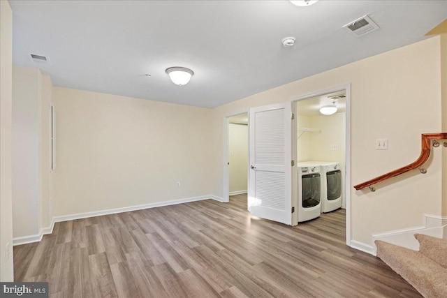 spare room with washing machine and clothes dryer and light hardwood / wood-style flooring