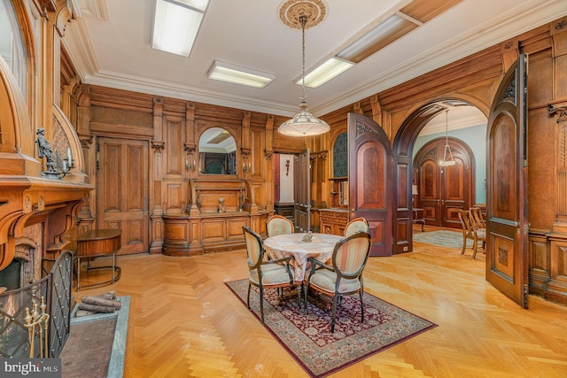 dining room featuring light parquet floors, ornamental molding, and wooden walls