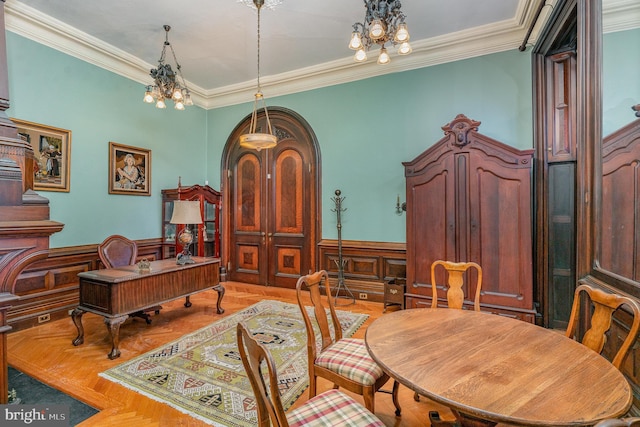 dining area with a notable chandelier, ornamental molding, and light parquet flooring